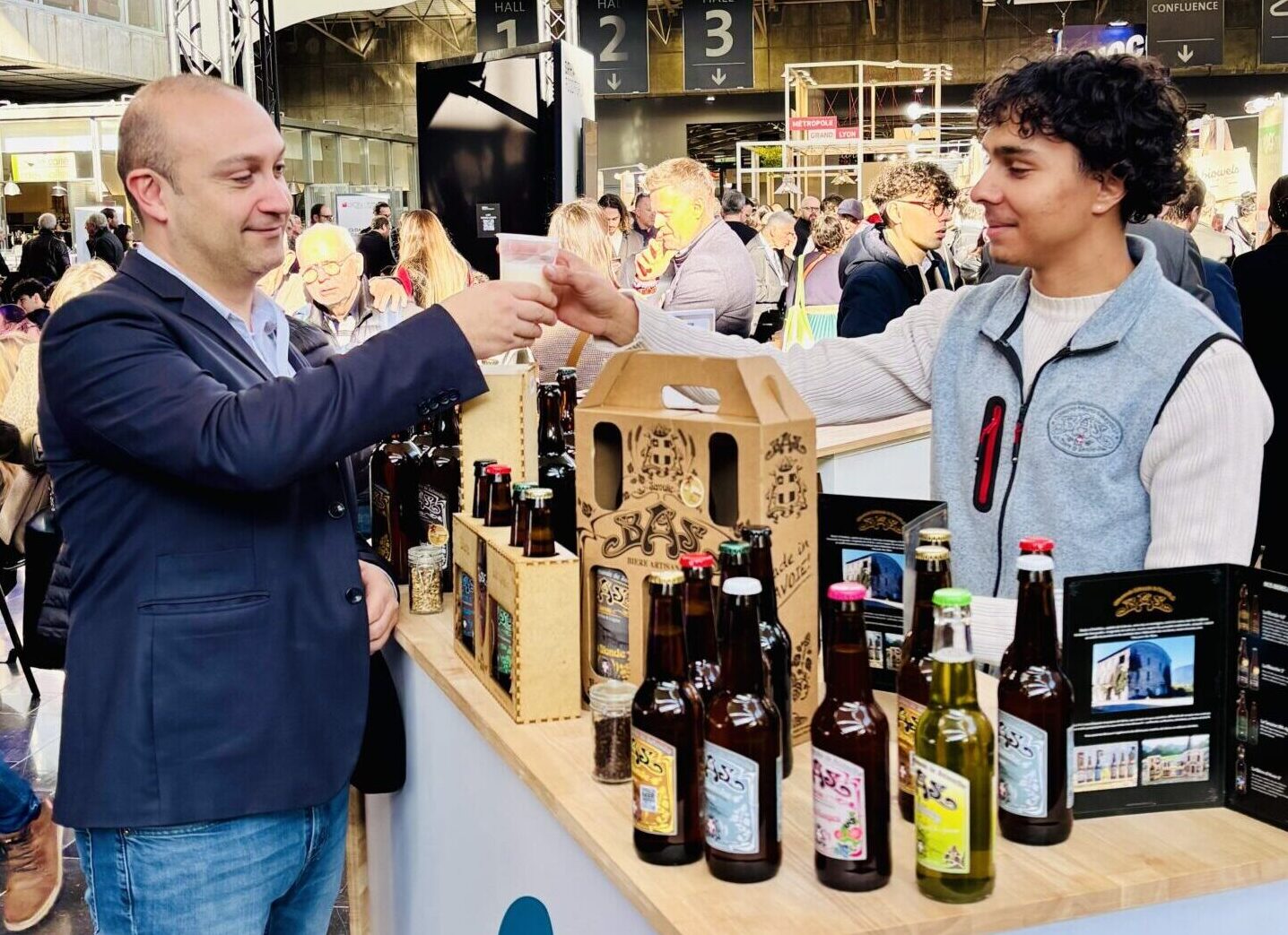 Stand de la Brasserie Artisanale de Savoie avec un animateur qui propose un petit verre de dégustation.