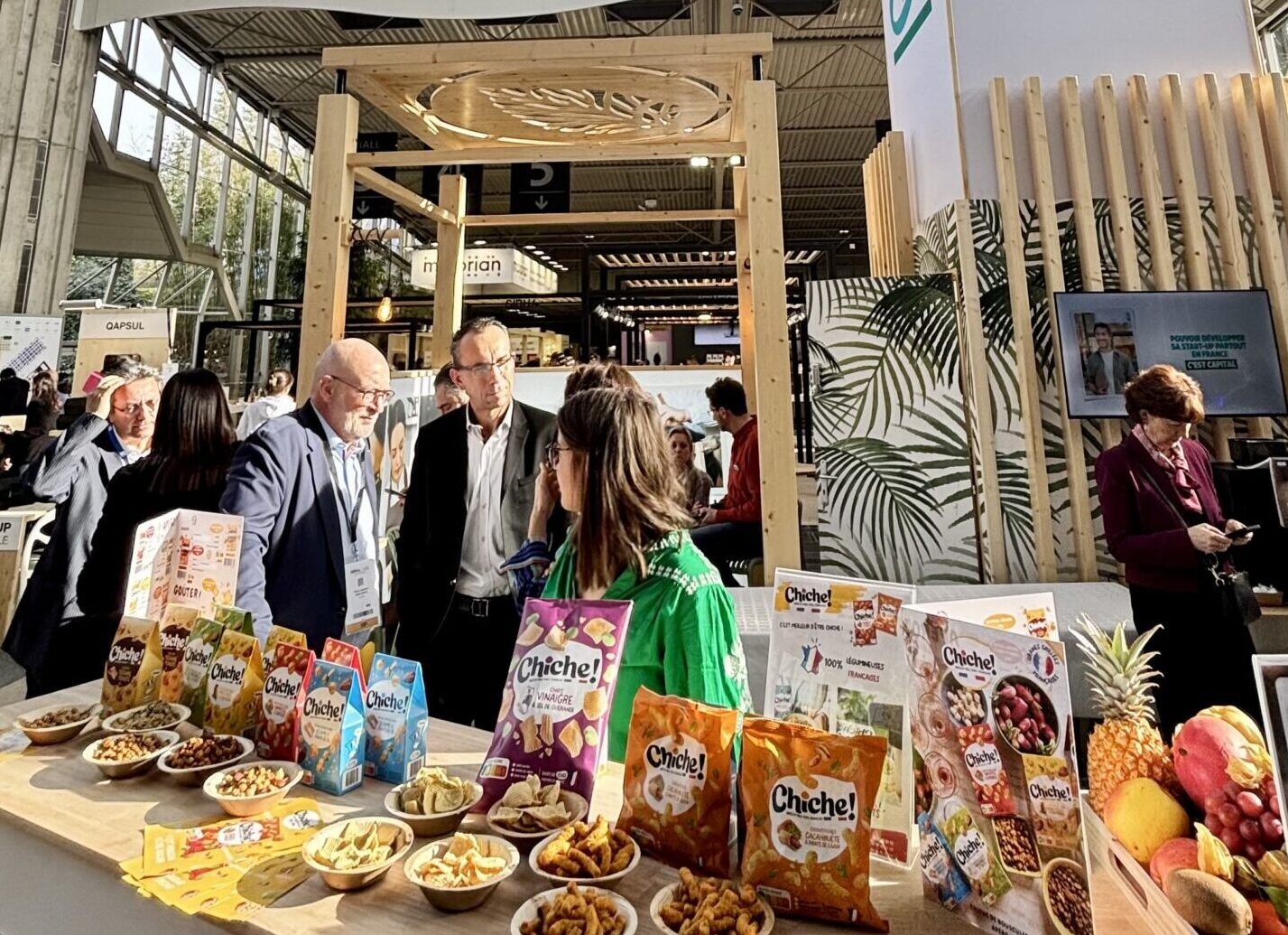 Stand de la marque "Chiche", sur la table, plusieurs paquets de différents apéritifs, chaque paquets à sa propre couleur.