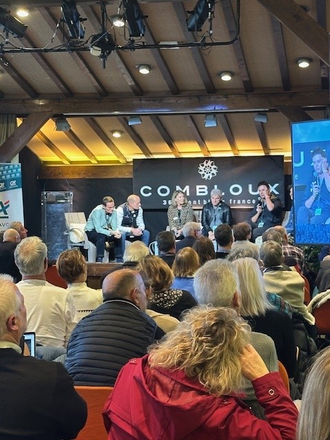 Public de dos, avec la scène en fond. Sur la scène des échanges entre plusieurs personnes.