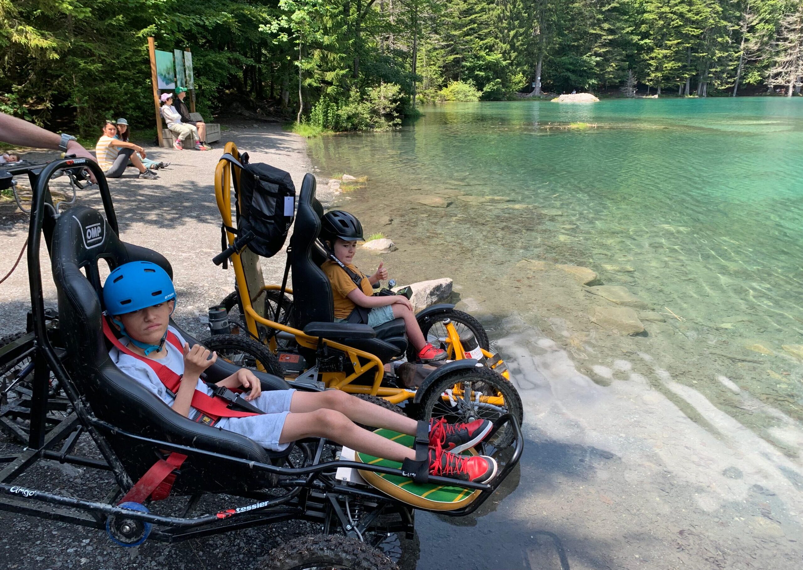 Enfant dans des poussettes / vélo au bord d'un lac de montagne.