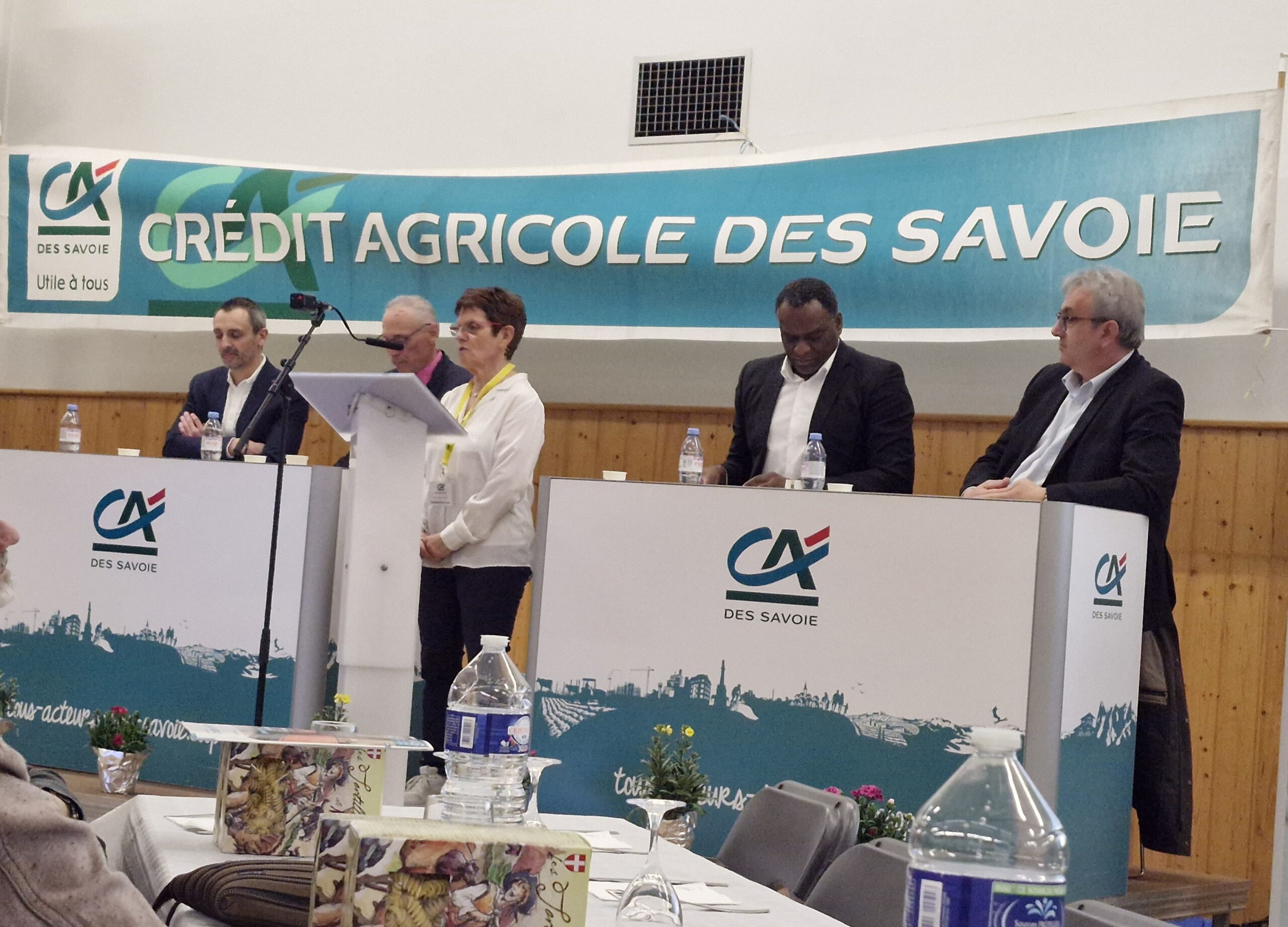 Sur scène, derrière des bureaux, des représentants du Crédit Agricole des Savoie.