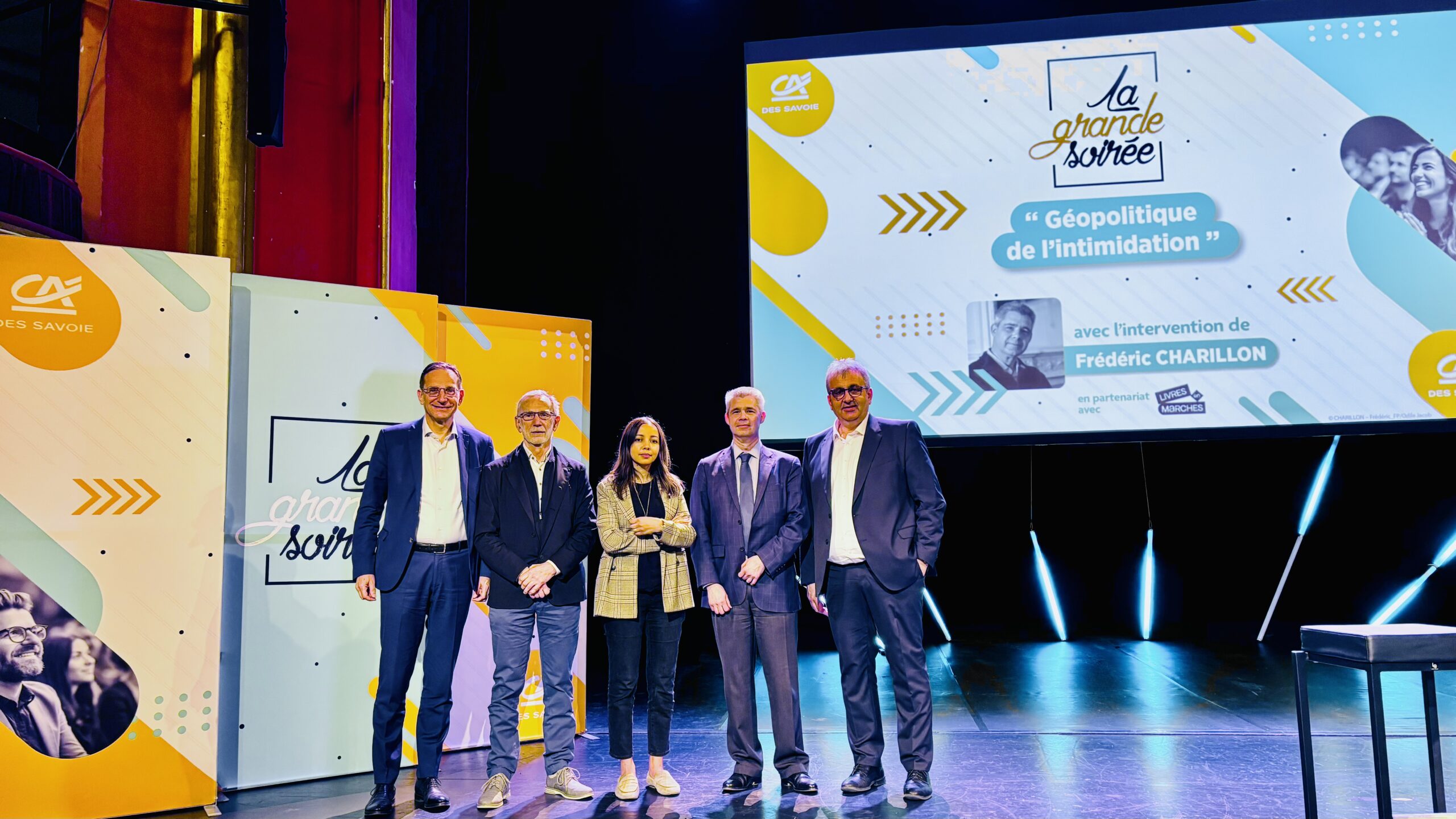 Sur scène, représentants du Crédit Agricole des SAvoie, le conférencier et l'animatrice.