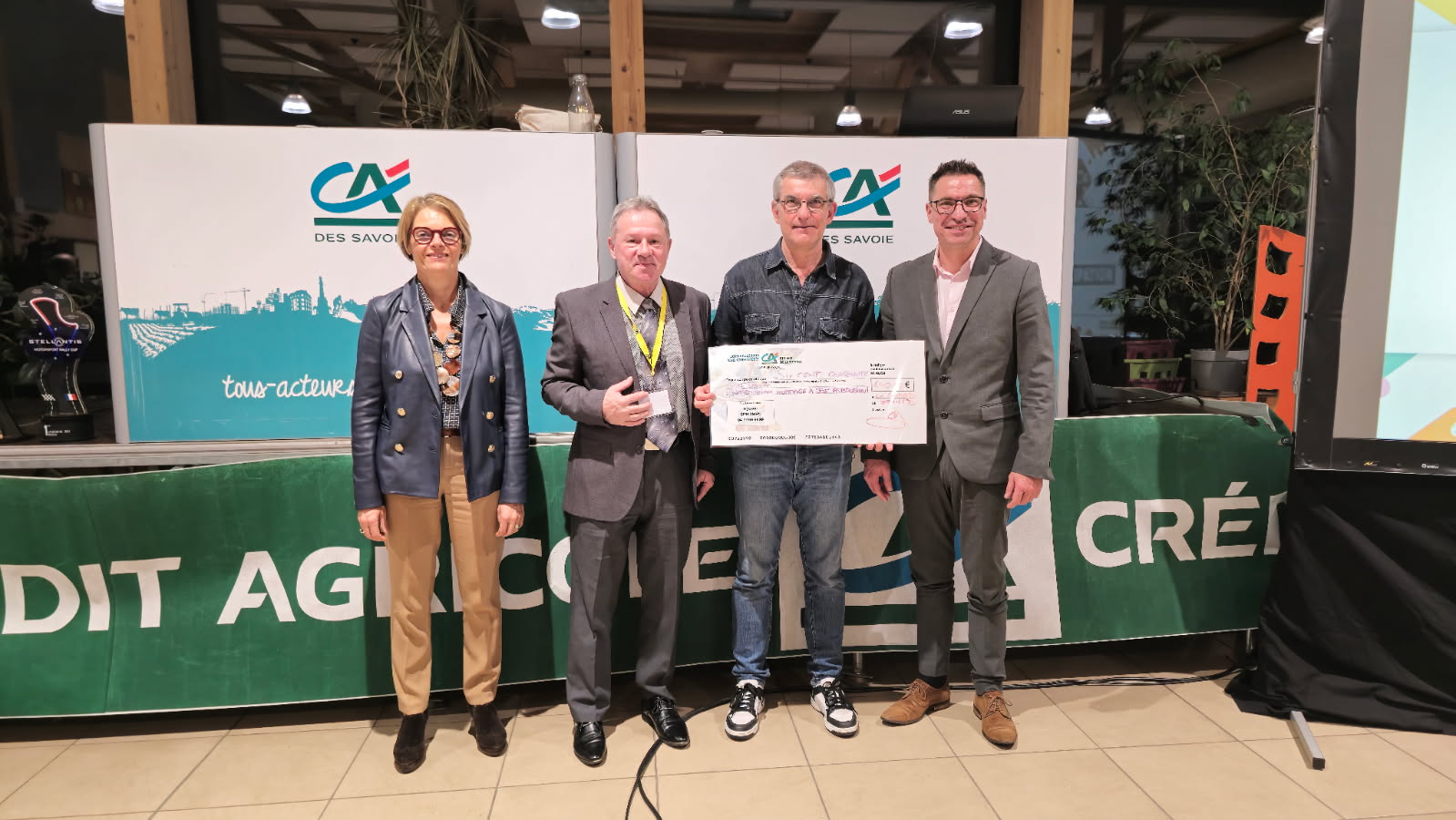 Remise d'un chèque, 4 personnes.