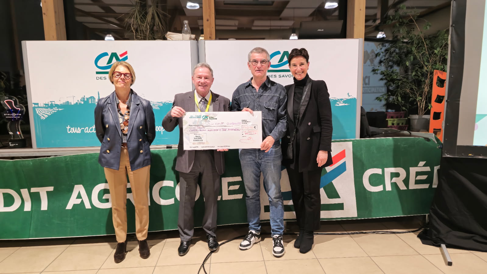 Remise d'un chèque, 4 personnes.