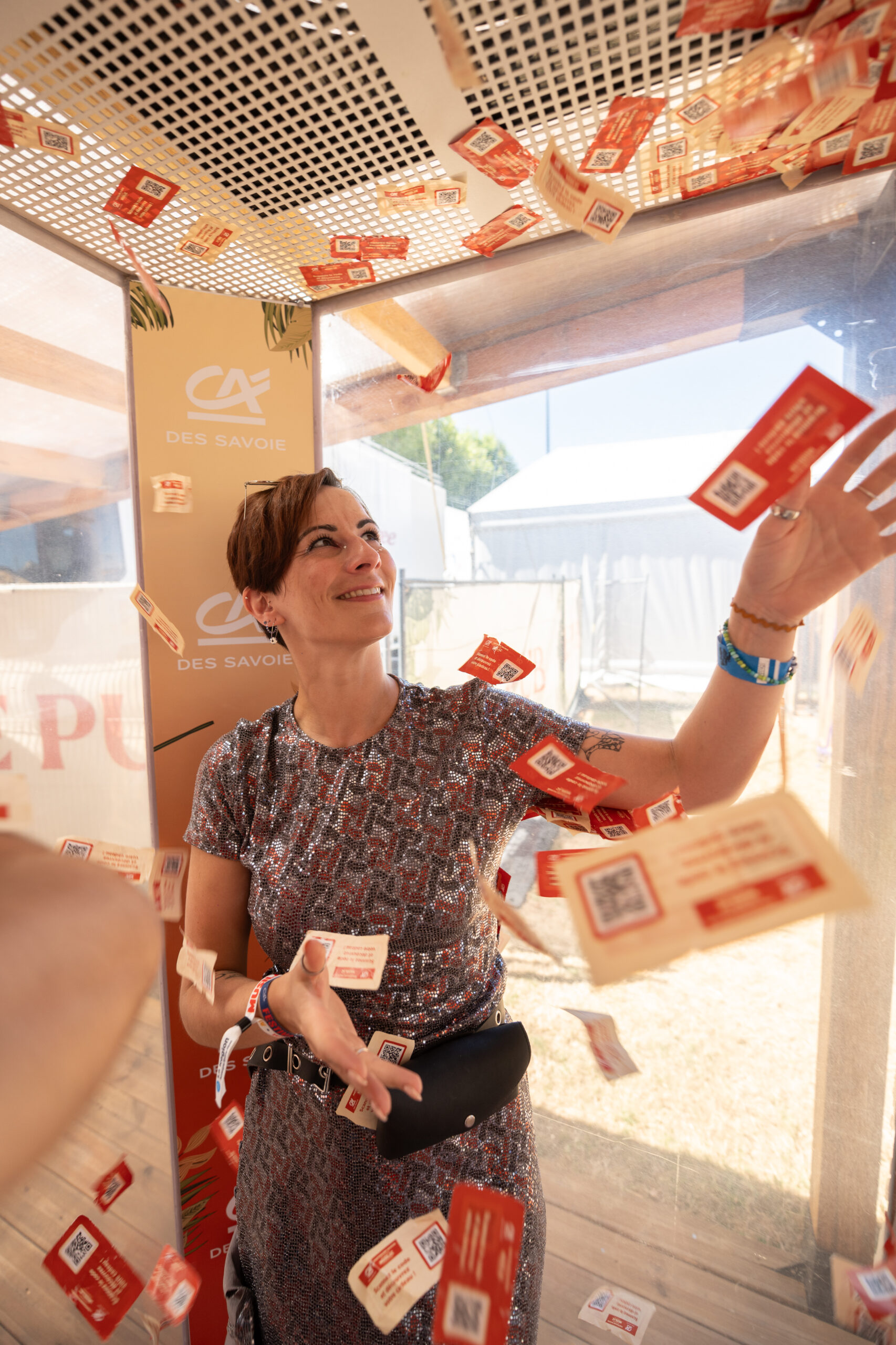 Personne qui tente d'attraper des billets qui volent dans la cash machine pour remporter des cadeaux.