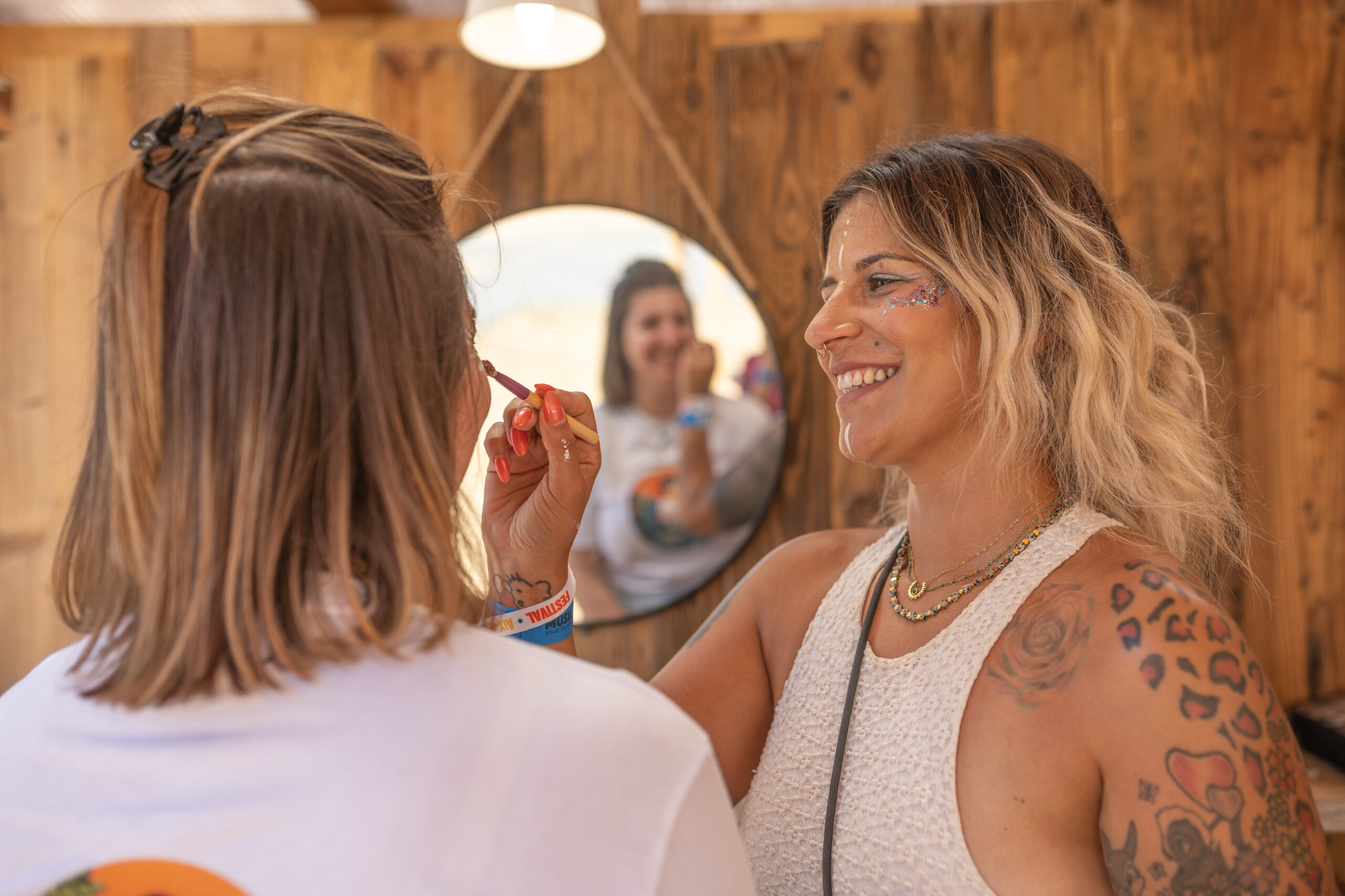 Maquilleuse du stand CA des Savoie qui maquille une festivalière de Musilac.