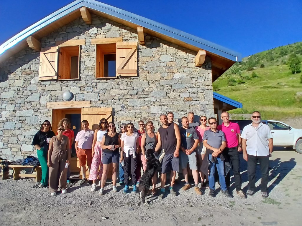 Regroupement de personnes de Caisses Locales devant un chalet d'altitude